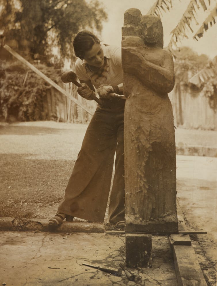 Woman makes big wooden sculpture