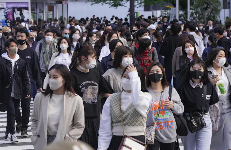 People on a street in Japan universally wearing face masks