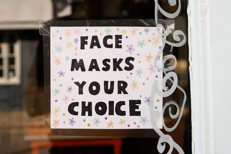 A sign in a shop window reading: 'face masks your choice'