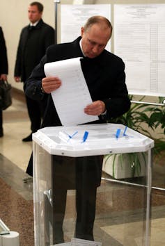 Putin holds a ballot paper as he votes at a polling station on Sept. 18, 2016 in Moscow