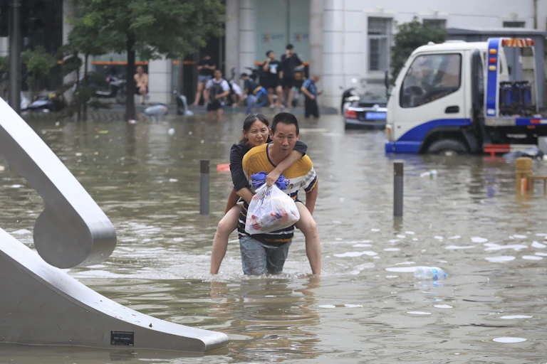 A man carries a woman through floodwaters in China