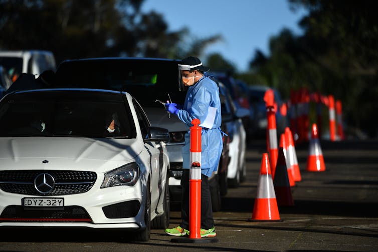 A health-worked in PPE at a drive-through testing clinic in NSW.