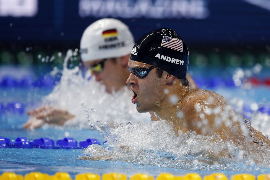 A photo of US Olympic swimmer Michael Andrew in a race as he comes up for air.