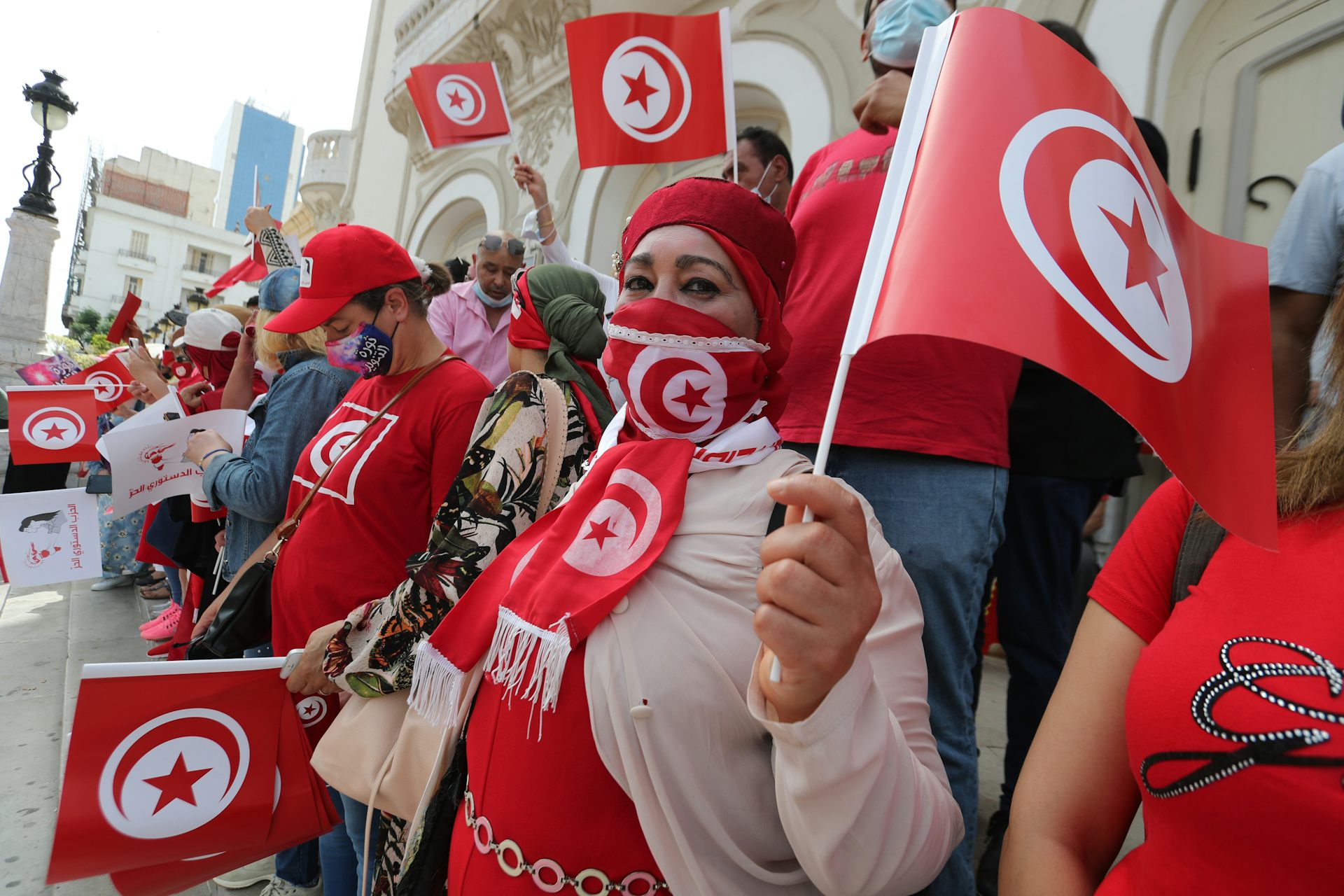 Supporters of Tunisia's Free Constitutional Party wearing read and waving the Tunisian flag on the streets of Tunis, July 2021.