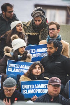 People hold signs indicating 