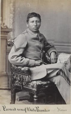 Black-and-white portrait of young man seated in chair