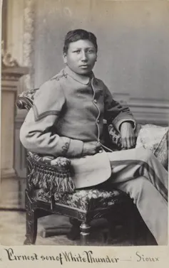 Black-and-white portrait of young man seated in chair