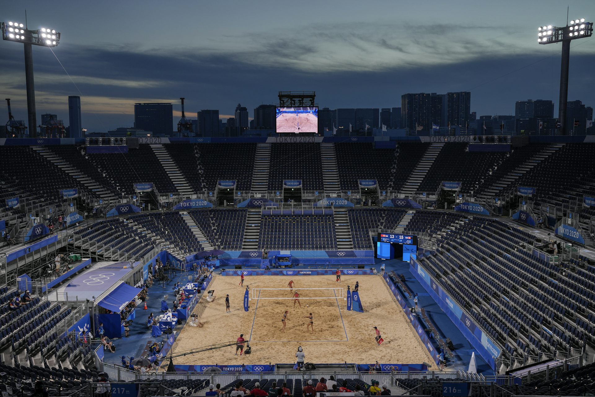 A beach volleyball game taking place in an empty stadium