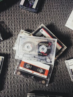 A collection of cassette tapes on grey carpet