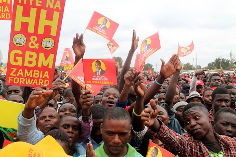 A youthful crowd carries banners bearing the face of Zambian opposition presidential candidate Hakainde Hichilema