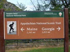 Sign shows distance to Maine and Georgia.