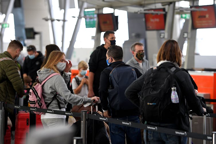 Passengers at Sydney airport line up to check package.