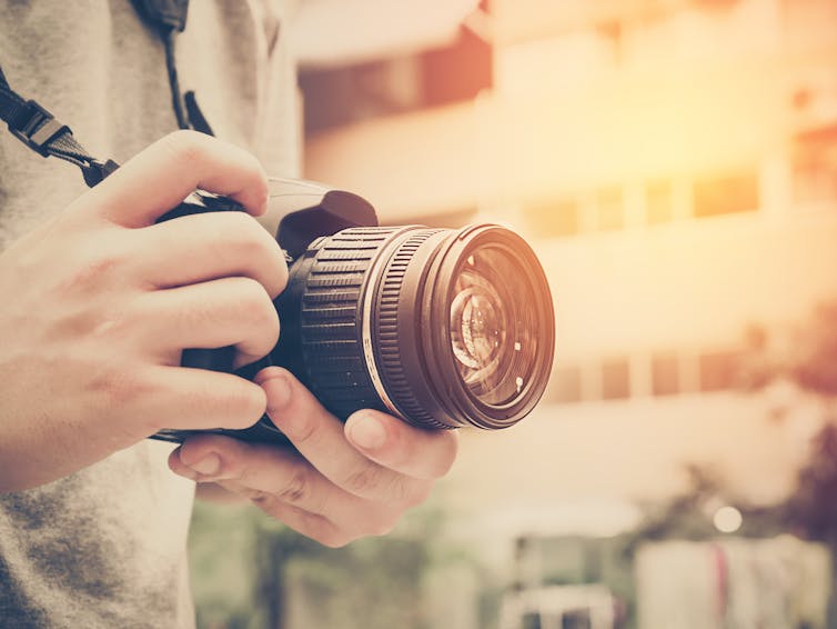 Young man holding camera.