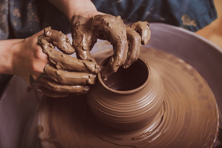 Woman's hands making pottery.