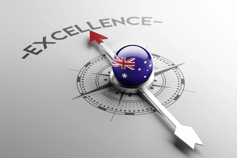 Compass needle with Australian flag globe at centre pointing to excellence