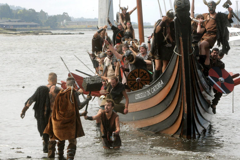 Men and women dressed as Vikings in a replica longship.
