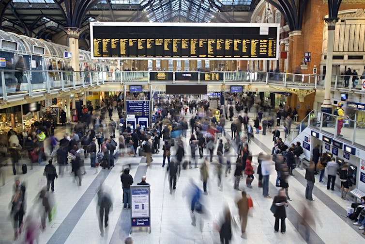 Liverpool Street Station in London as crowds of people rush through.