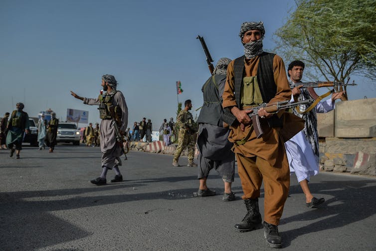 Fighters with guns stand on a road