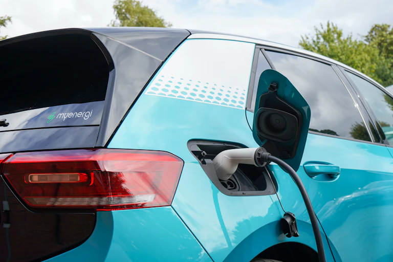 Electric car (bright aqua) is seen charging
