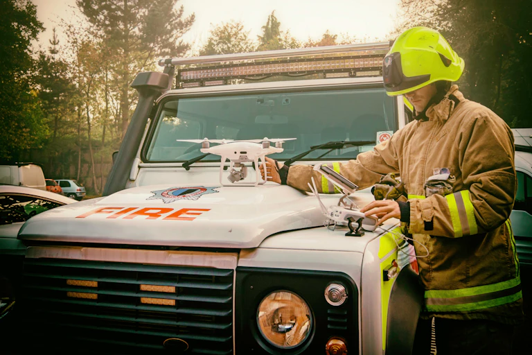 A firefighter prepping a drone on the hood of a fire truck