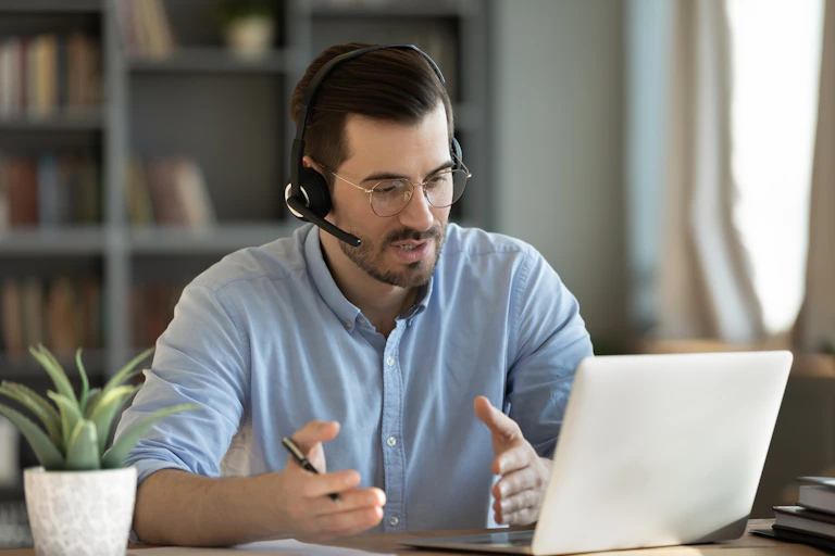 Teacher at the computer with headphones and microphone
