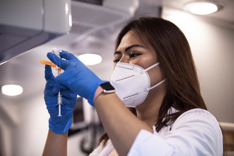 An immunisation nurse draws up a COVID-19 vaccination.