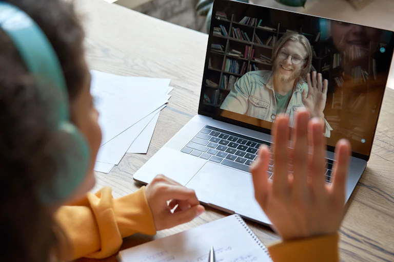 young student and online tutor wave to each other