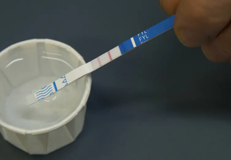 A test strip in a paper cup