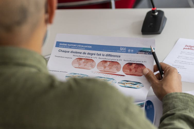 A person looks at a print-out of maps on the IPCC report