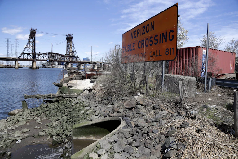 Rubble and a bridge next to a river.