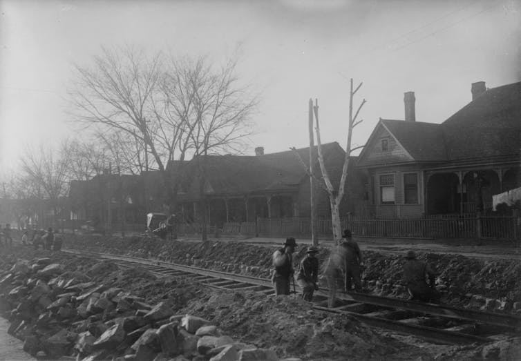 A black and white photo of people working to build a railroad.