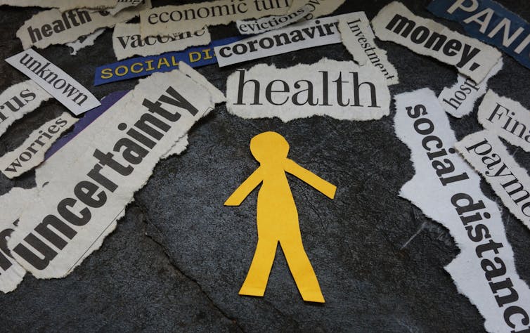 Yellow paper cut out figure against mental health words