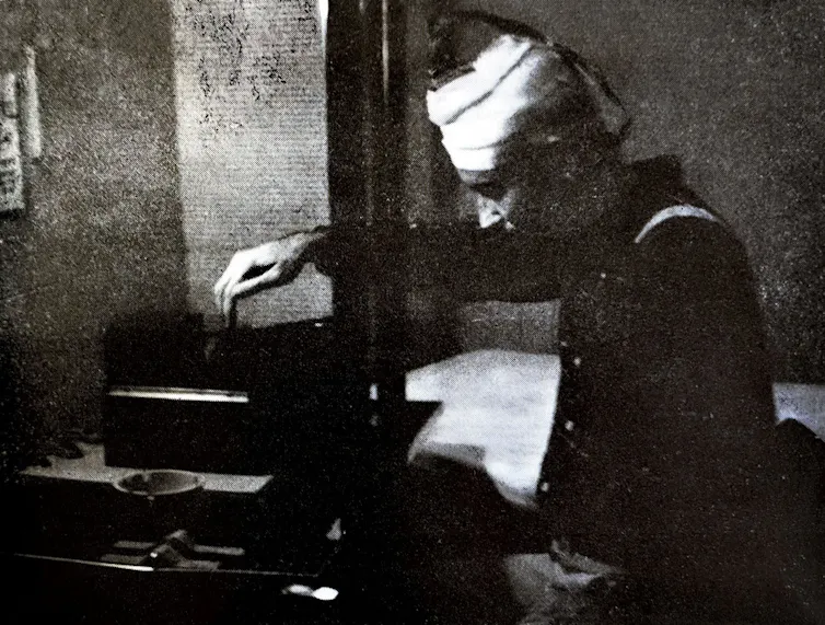 Black and white grainy photograph of a person pressing a button.