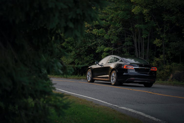 An electric vehicle drives through the forest