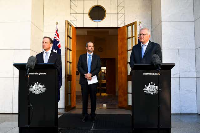 The AMA president stands between the health minister and prime minister.