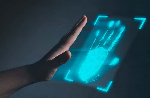 A person scanning their hand on a glowing blue scanner