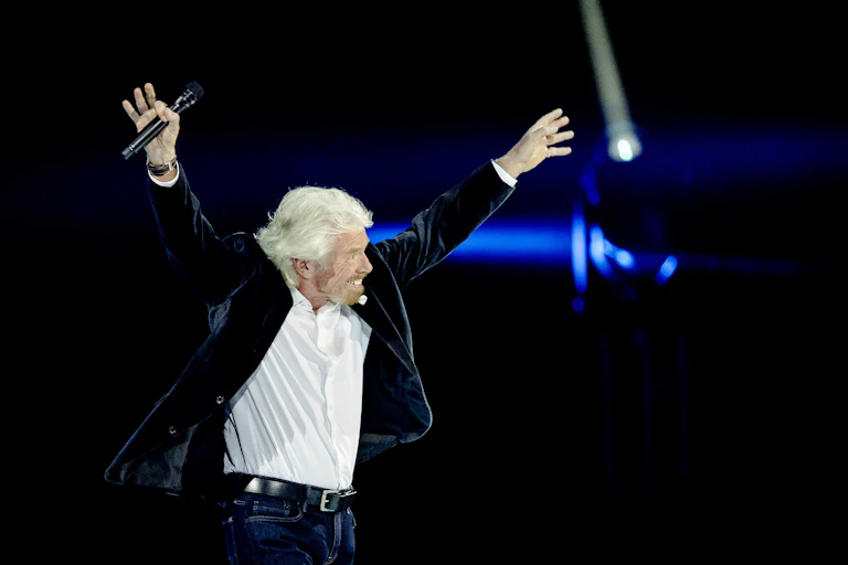 Richard Branson with his arms in the air