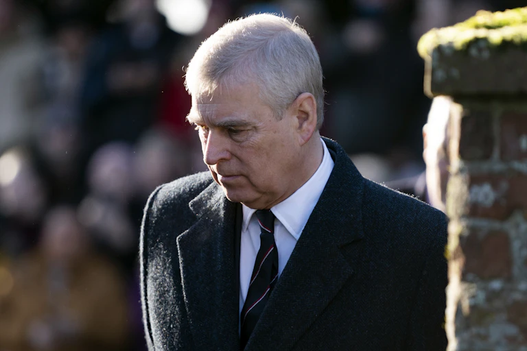 Prince Andrew with his head tilted downwards and a solemn expression.