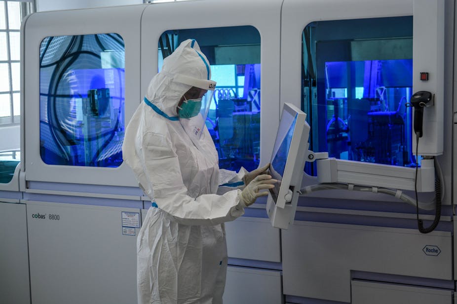 A technician handles samples from truck drivers testing for COVID-19 coronavirus at the laboratory of Kenya Medical Research Institute (KEMRI) in Busia