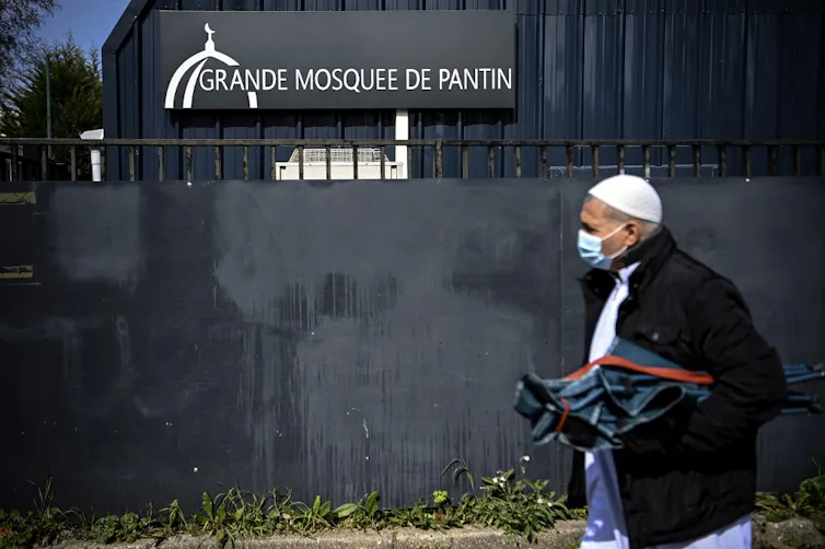 A Muslim worshipper arrives for the Friday prayers to the Grande Mosquee de Pantin