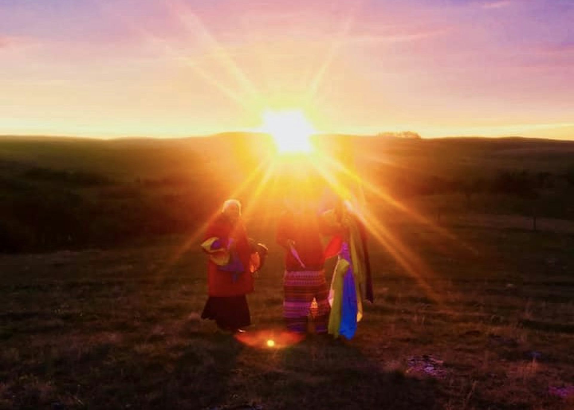 Woman in traditional Indigenous attire leads sunrise ceremony