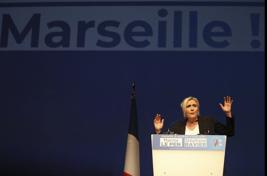 Marine Le Pen gives a speech in front of a banner that says, 'Marseille', March 2020. 