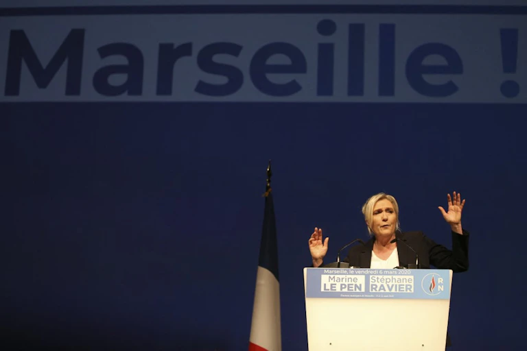 Marine Le Pen gives a speech in front of a banner that says, 'Marseille', March 2020.