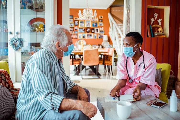 Health care worker talking to an older patient.