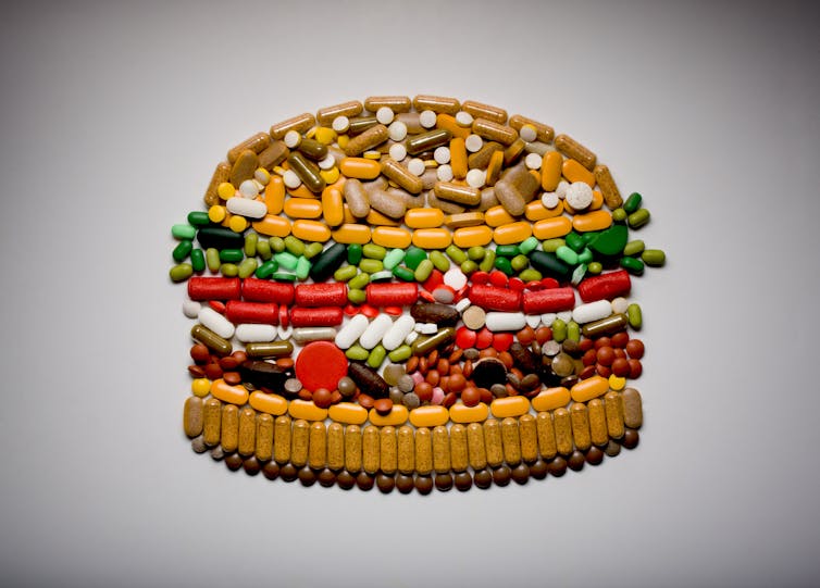 A collage of pills in the shape of a hamburger.