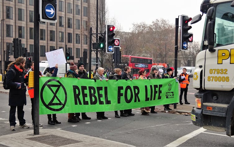 Protestors carry a banner reading 'Rebel For Life'