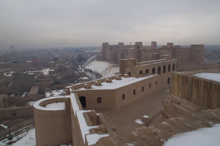 A large fortified building overlooks a city