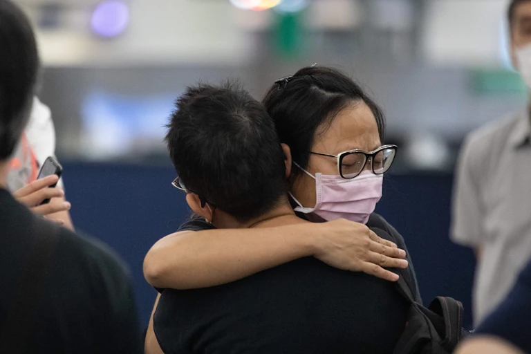 A woman hugs her friend as she departs, at Hong Kong international airport.