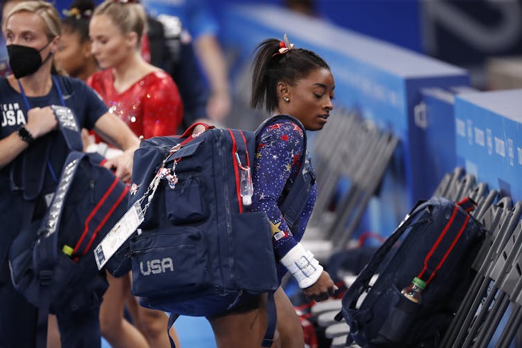 Simon Biles carrying bag in Olympic costume