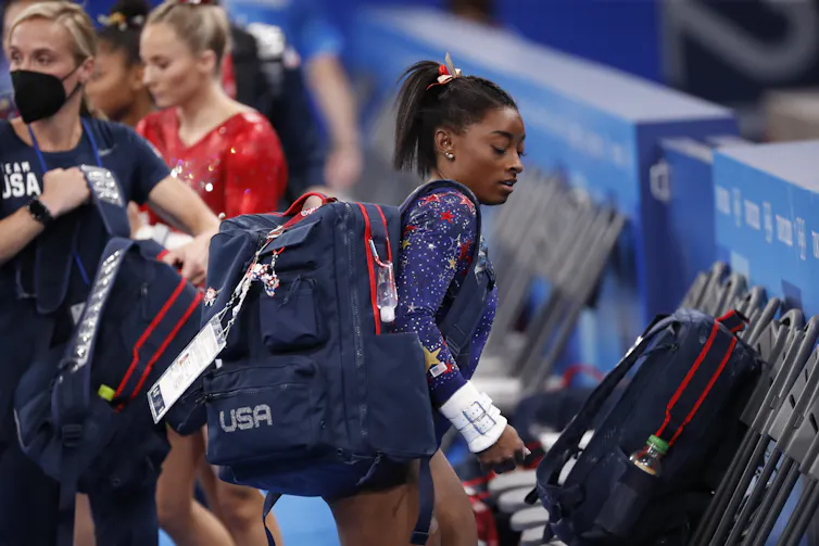 Simon Biles carrying bag in Olympic costume